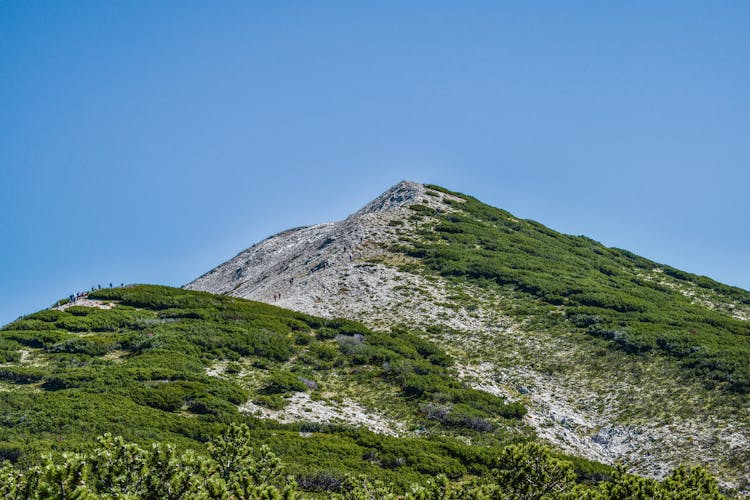 People Hiking Up Grassy Mountain