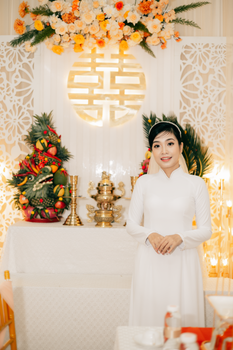 A beautiful bride in traditional attire stands by an ornate altar during a wedding ceremony.