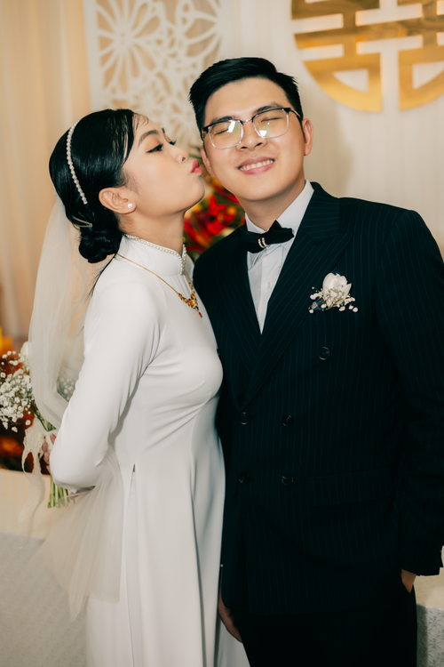 Free Wedding couple in traditional attire sharing an affectionate moment indoors. Stock Photo