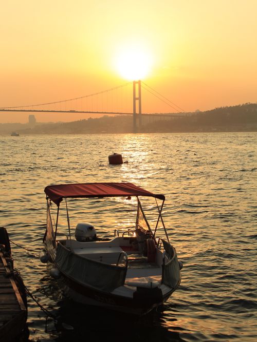 Free Serene sunset view of a boat docked at Bosphorus in Çengelköy, overlooking a suspension bridge. Stock Photo