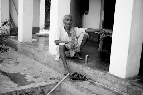 Elderly Man Sitting at Porch