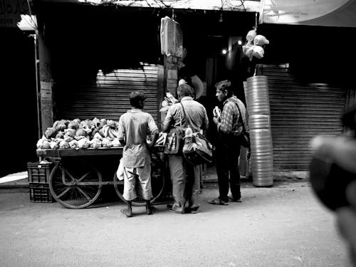 A Grayscale Photo of Men Standing on the Street