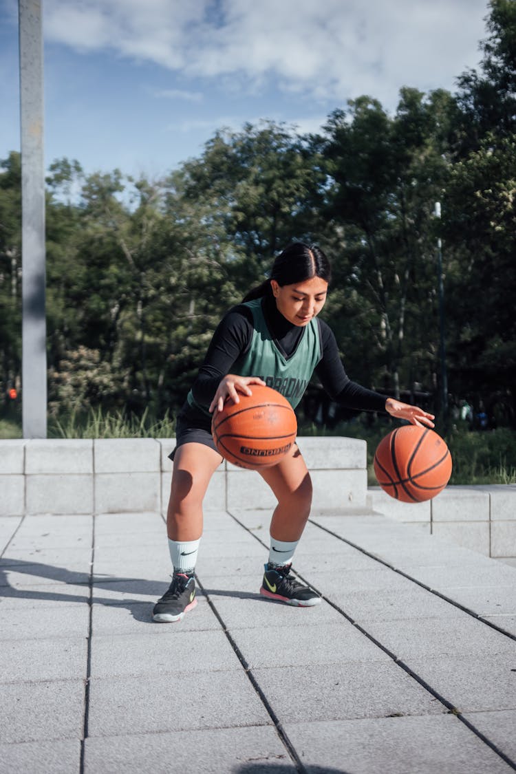 Woman Bouncing Two Basketball Balls 