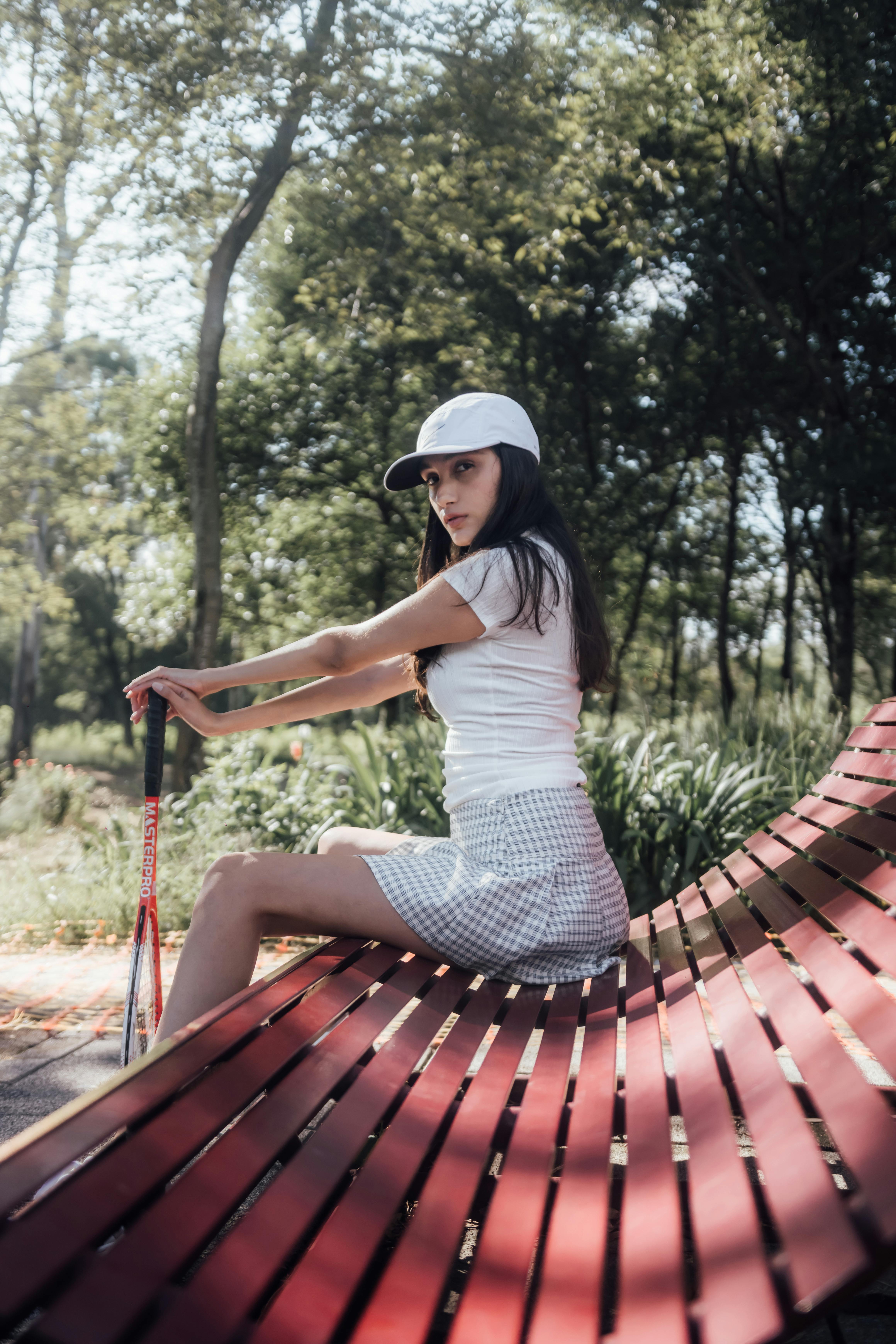 woman in golf clothing holding a club and sitting on a bench