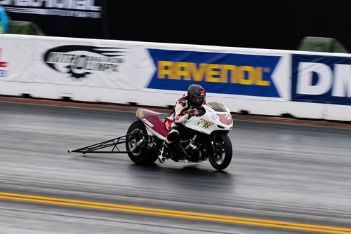 Free Motorcyclist in action during a race on a wet drag strip track. Stock Photo