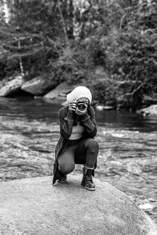 Grayscale Photo of a Female Photographer Taking Picutre