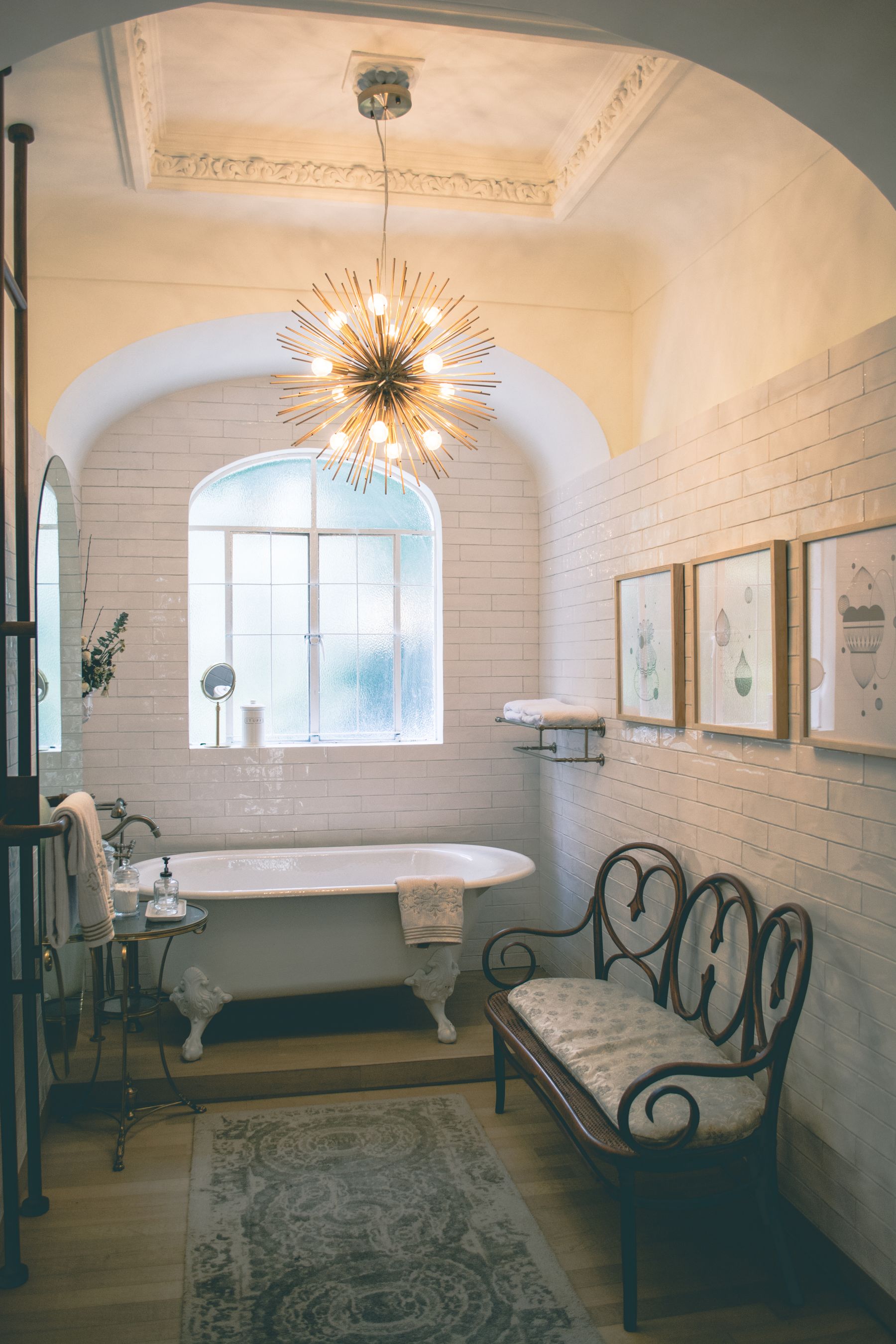 Vintage bathroom with clawfoot bath and decorative chandelier