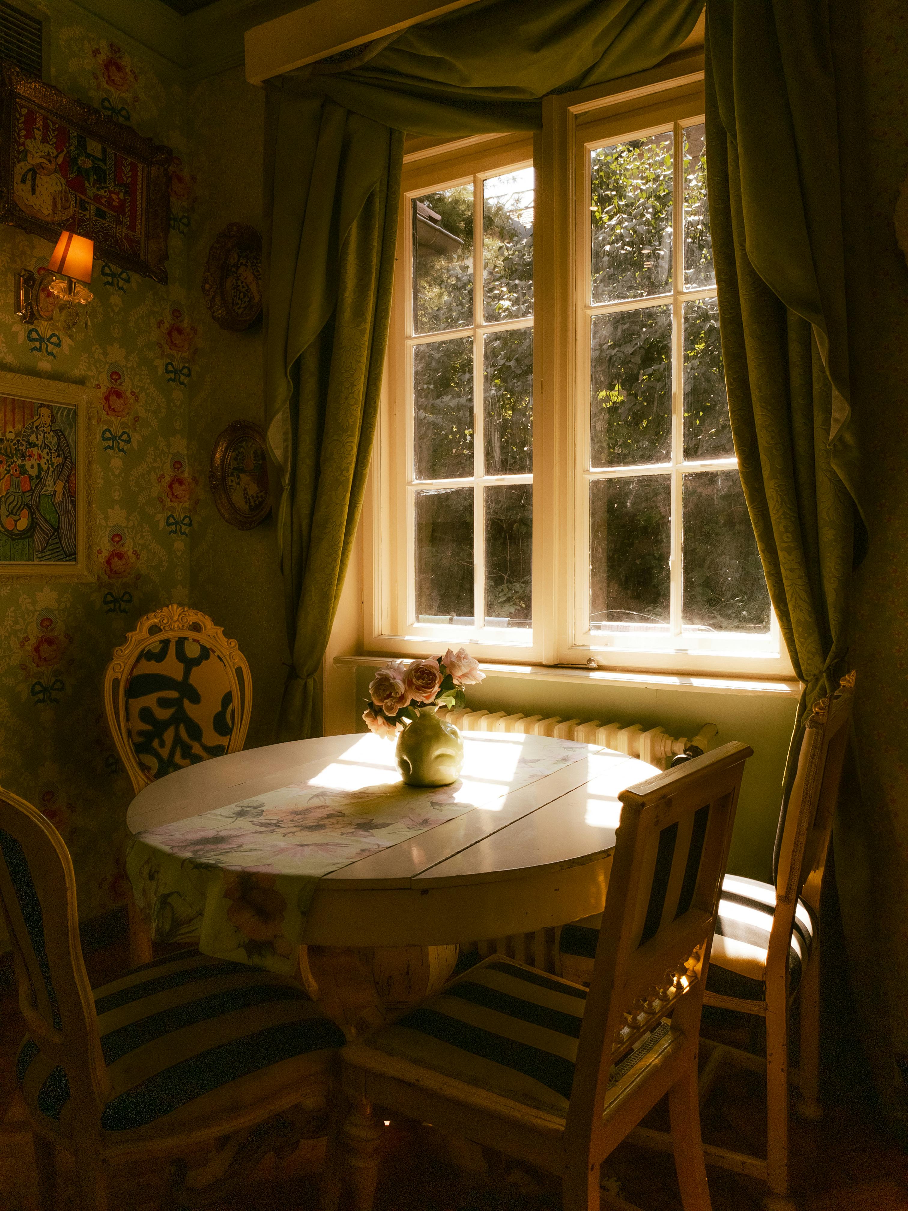 Cozy rustic dining room featuring vintage decor bathed in warm sunlight through a window.