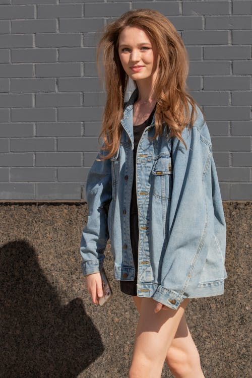 A Woman in Denim Jacket Standing on the Street