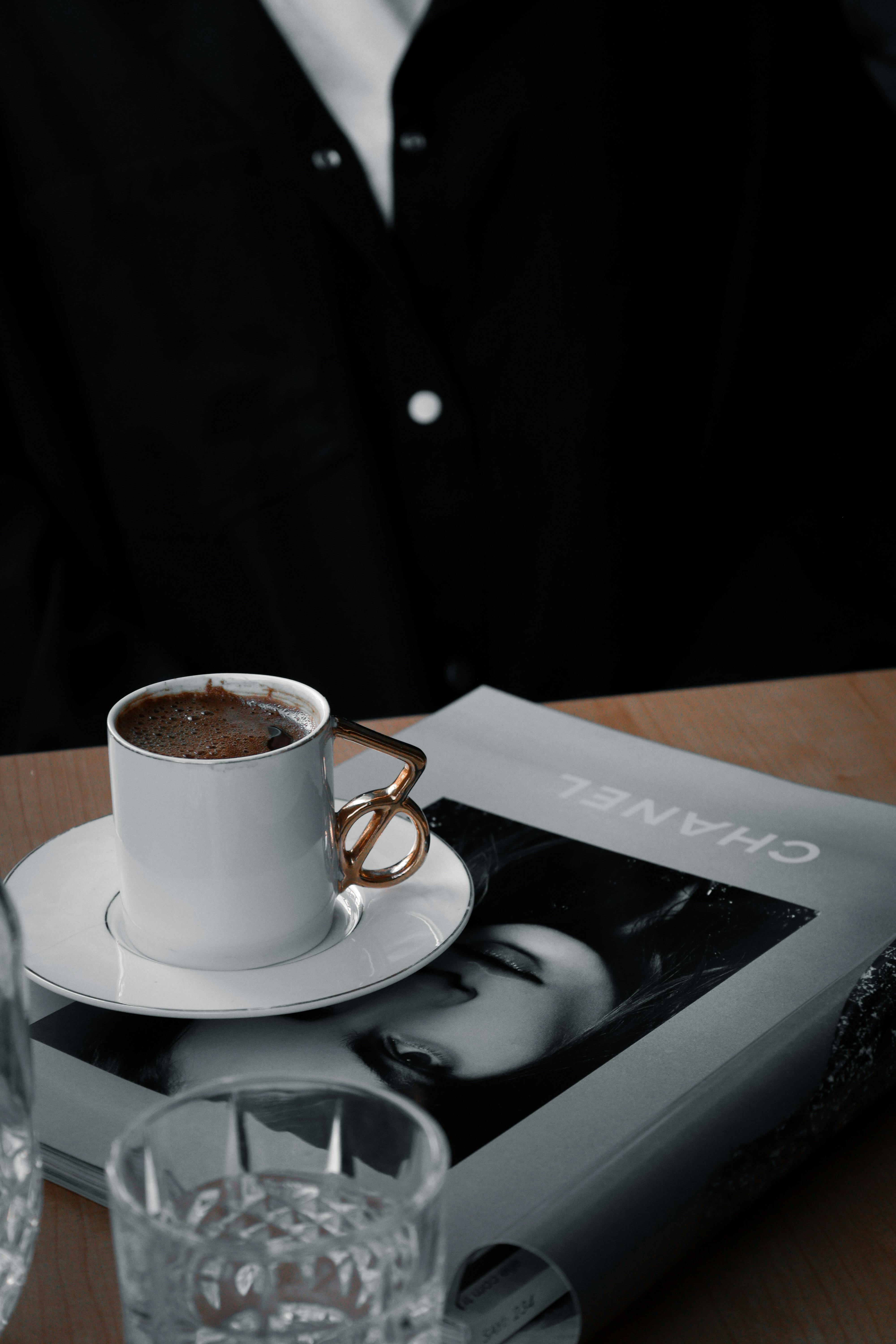 A chic coffee setup with a designer book and elegant cup on a wooden table. Perfect for lifestyle insights.