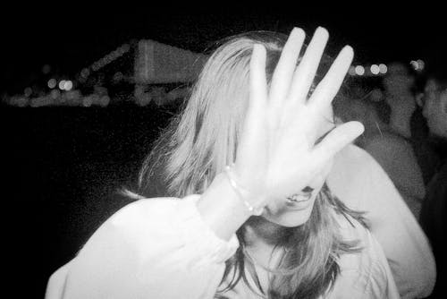 A Woman in White Long Sleeves Covering Her Face