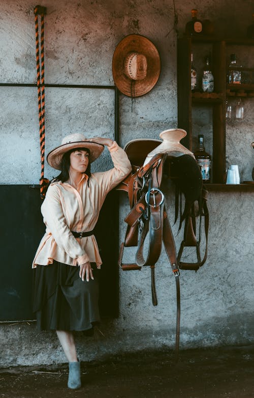 Woman Posing near Cowboy Accessories 