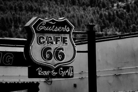 Classic black and white photo of a Route 66 cafe sign, evoking vintage Americana.