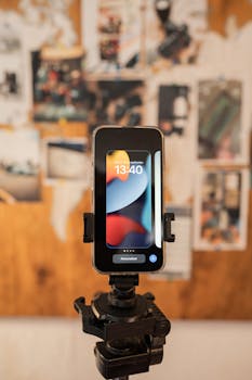 A smartphone mounted on a tripod with a blurred background, showing 13:40 time.