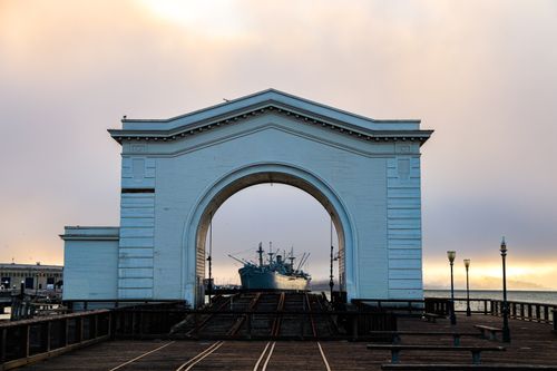 Free Capture of Pier 43 Ferry Arch in San Francisco at sunset with a ship in view, iconic landmark. Stock Photo