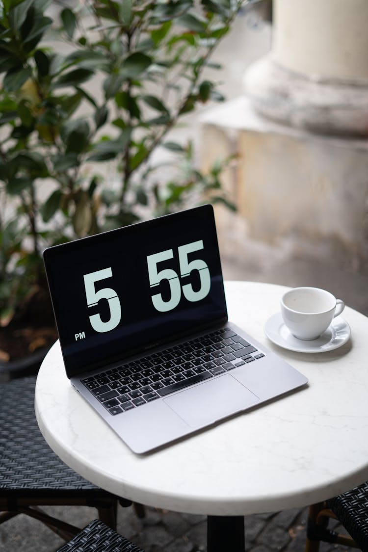 Laptop And Coffee Cup On Cafe Table Outdoors