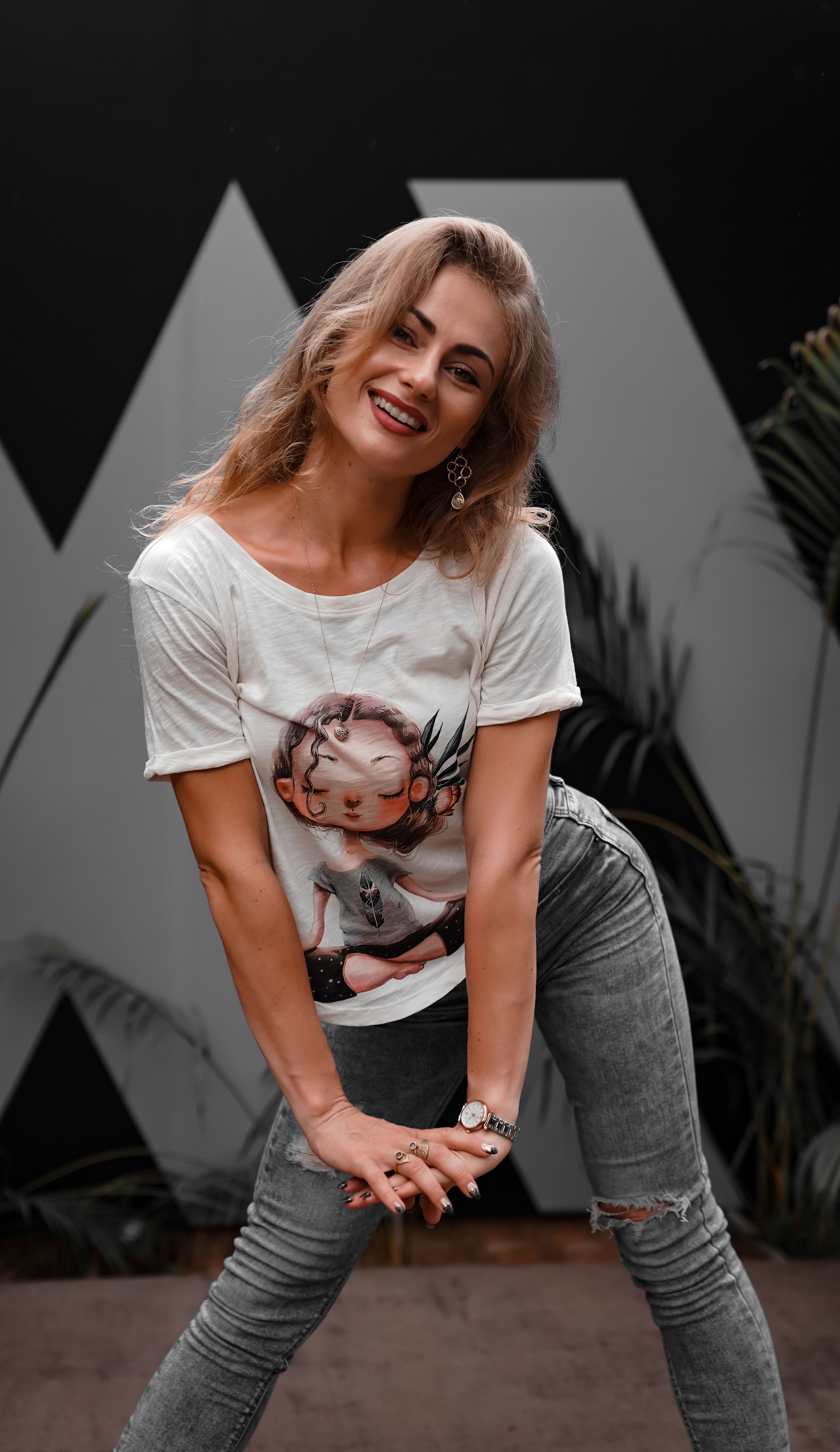 Cheerful woman posing stylishly in casual outfit, enjoying an outdoor setting.
