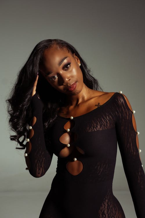 A Sexy Woman in Black Dress with Her Hand on Her Hair