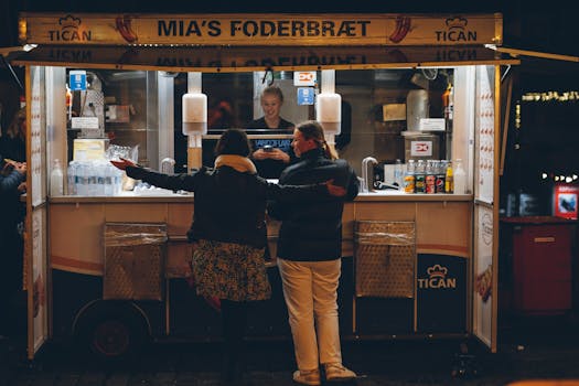 Women buying food at a street stand at night in Copenhagen, Denmark.