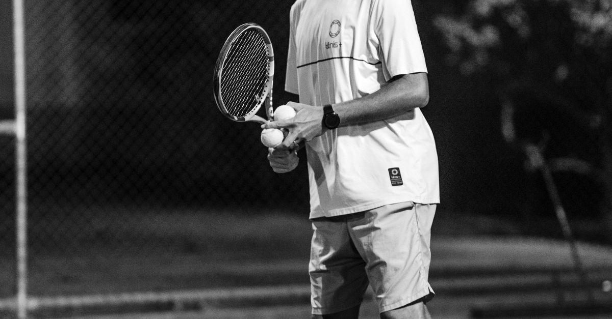 A Grayscale Photo of a Man Holding a Tennis Racket · Free Stock Photo