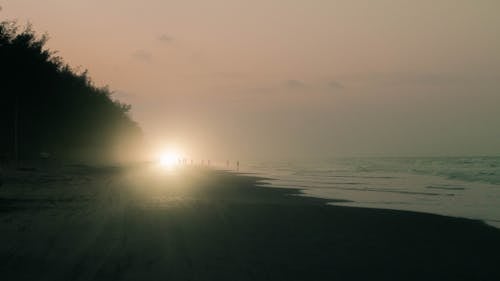 Car with the lights on at sunset on the beach of Tuxpan Veracruz in Mexico