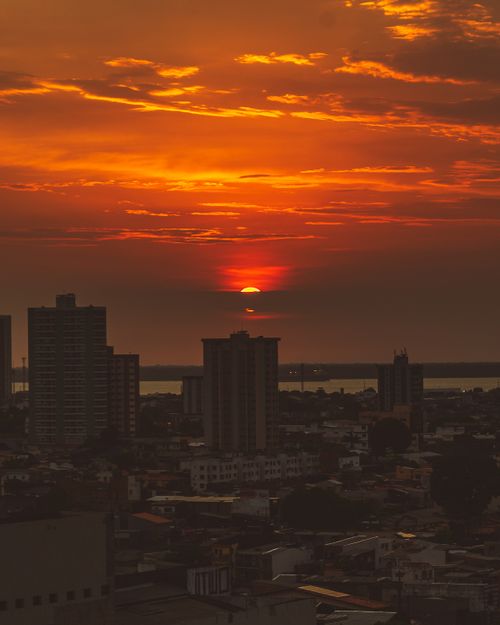 Free A breathtaking urban skyline silhouetted against a vivid sunset sky, capturing the essence of golden hour. Stock Photo