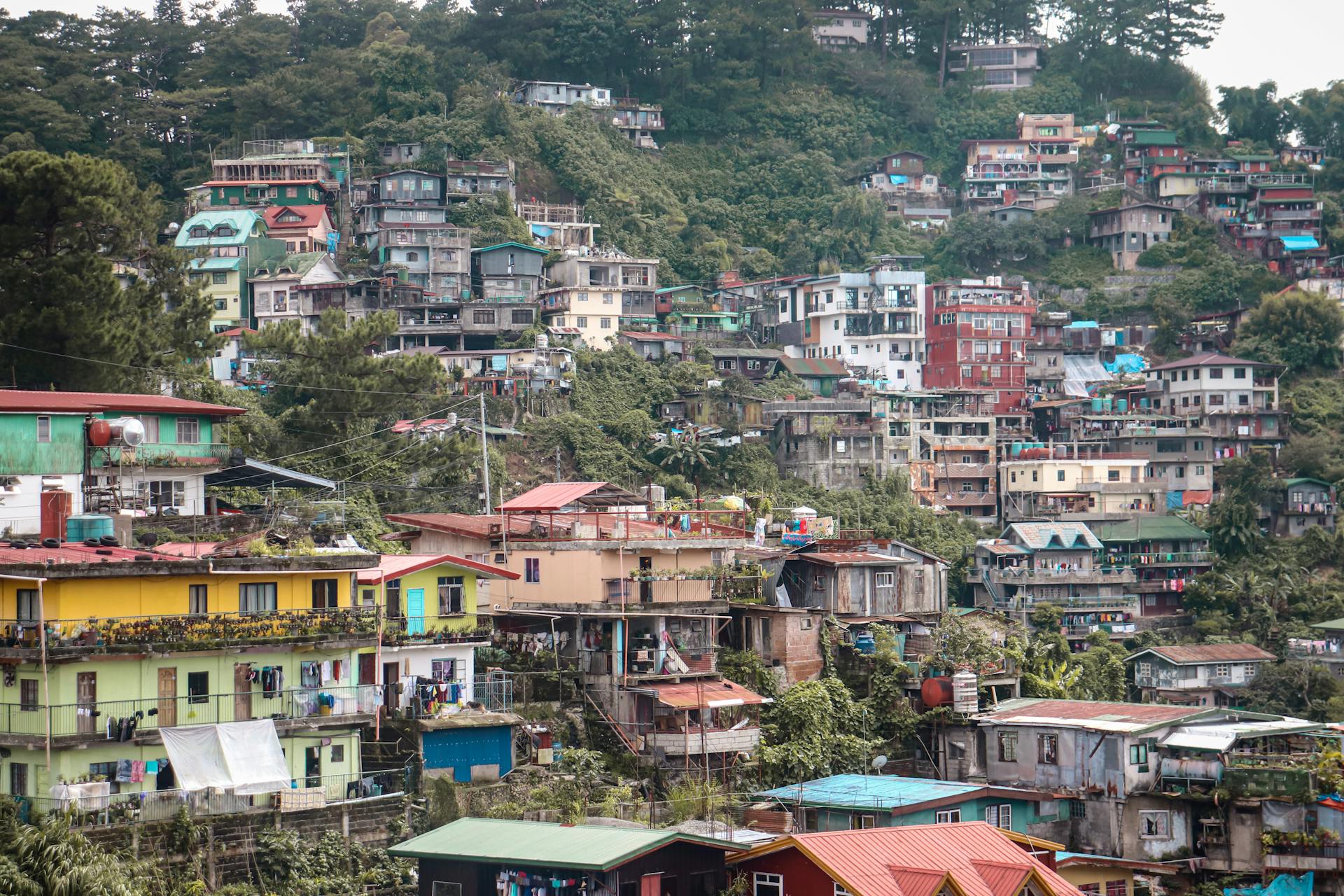 Dense hillside residential area in Baguio, Philippines showcasing colorful buildings and lush greenery.