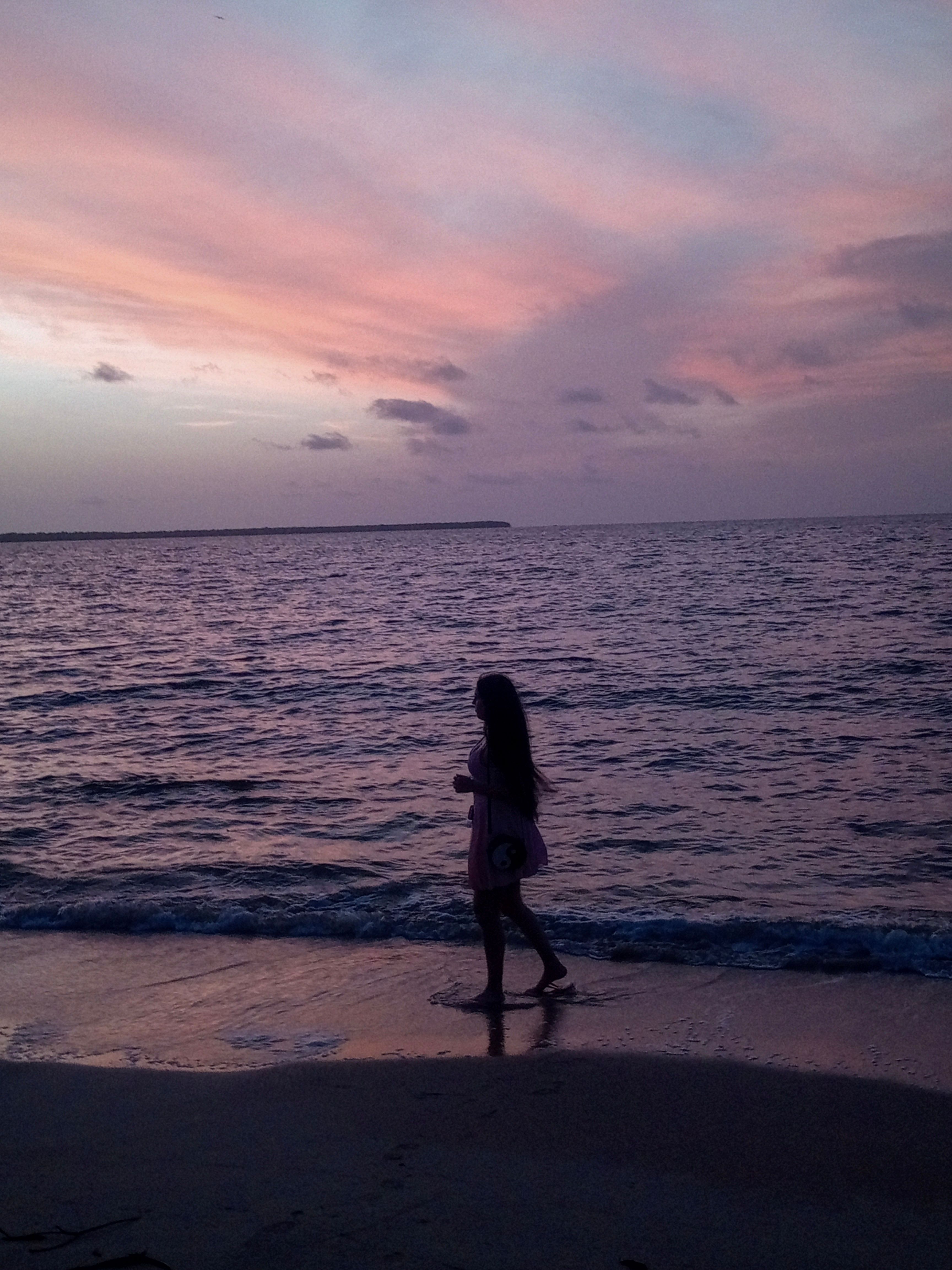 Silhouette of a Woman on a Beach at Sunset · Free Stock Photo