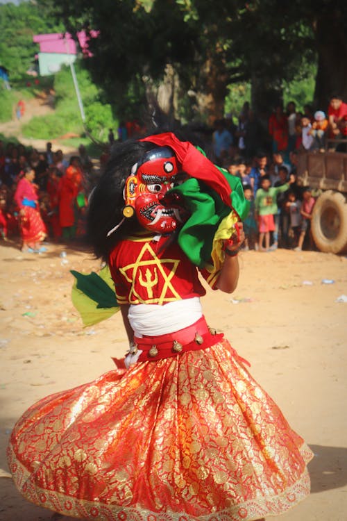 A Person Dancing in a Mask and a Costume 