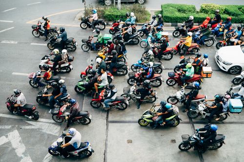 Free A crowded city street filled with motor scooters at an intersection, highlighting urban transportation. Stock Photo