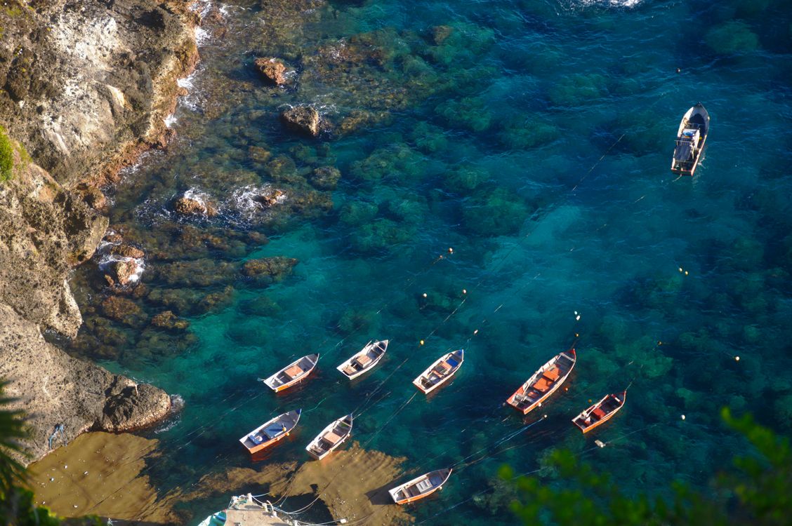 Boats Moored near Rocks on Sea Shore · Free Stock Photo