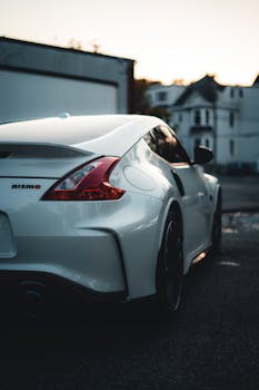 Sleek Nissan Nismo sports car rear view in a city street during twilight.