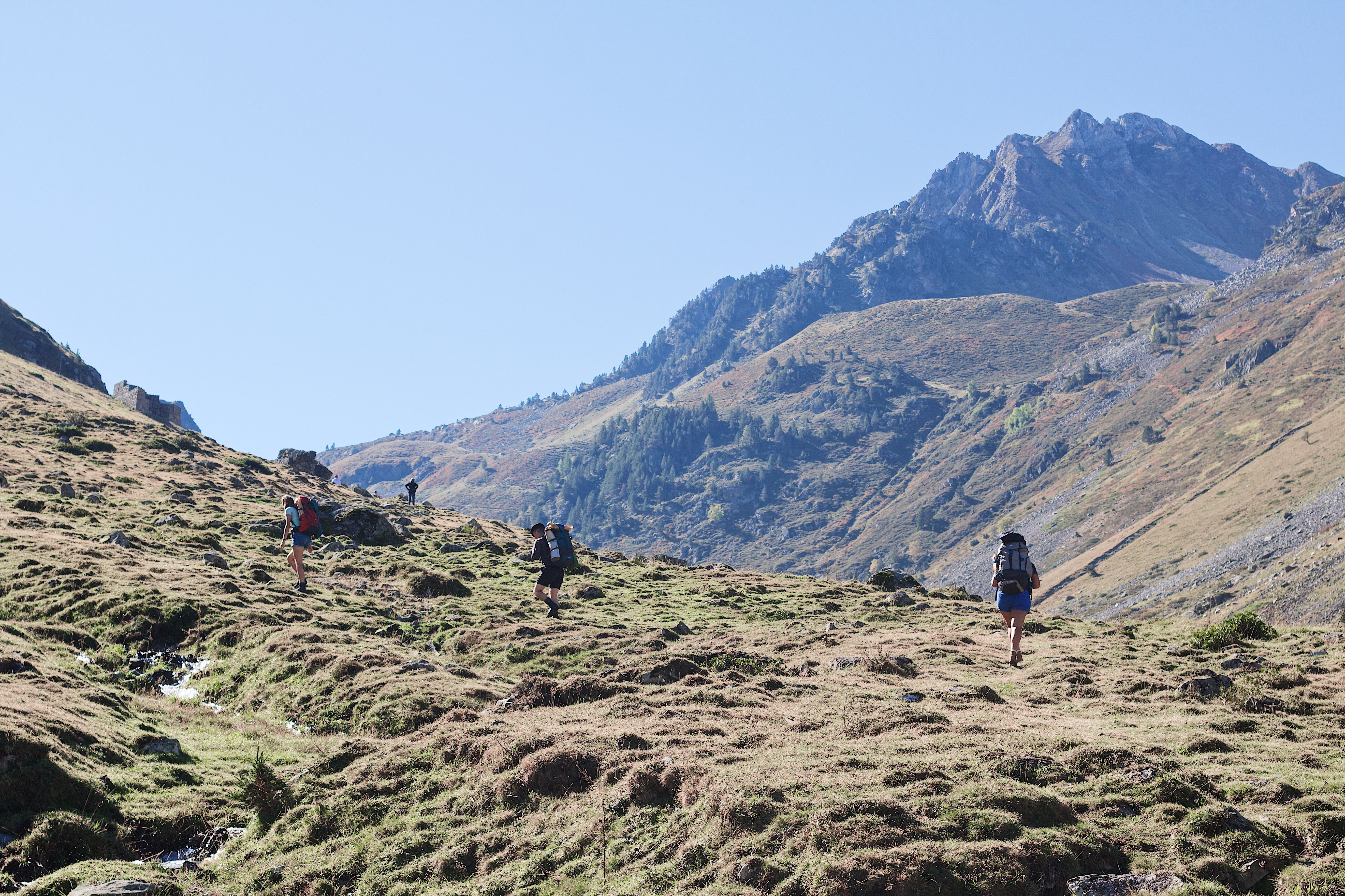 Grupo de personas caminando por un paisaje de montaña