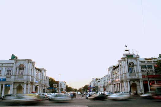 Traffic flows through the historic Connaught Place intersection as dusk settles, capturing the city's vibrant life.