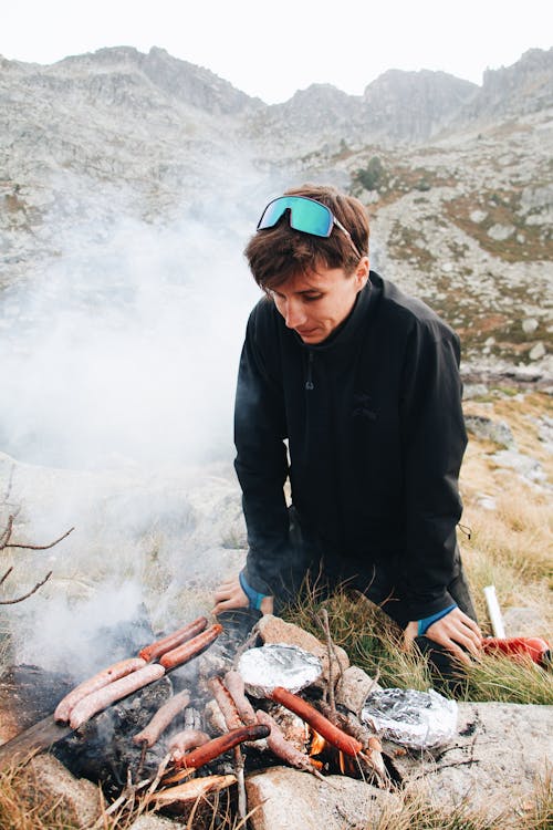 Photo of a Man Cooking Sausages