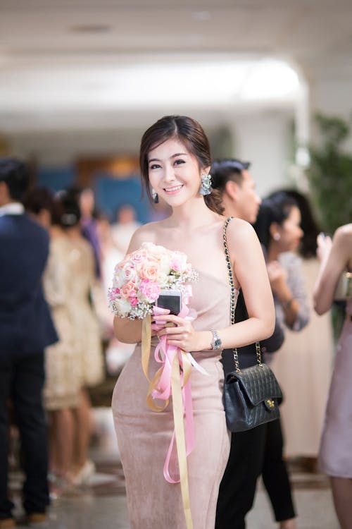 Wanita Dengan Gaun Bodycon Pink Strapless Memegang Bunga