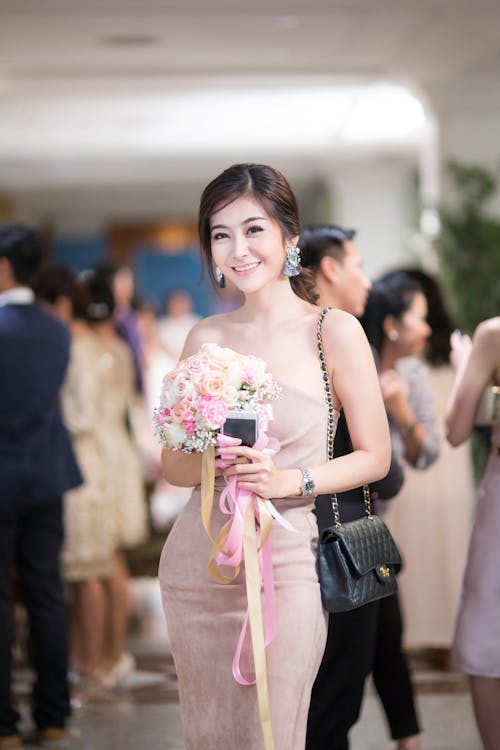 Woman in Pink Strapless Bodycon Dress Holding Flowers