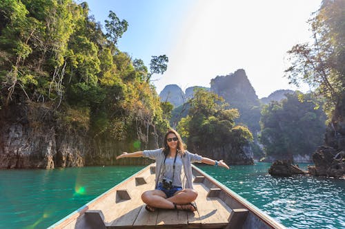 Gratis Foto De Mujer Sentada En Un Barco Extendiendo Sus Brazos Foto de stock