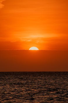 Capture of a vibrant sunset over the ocean in Cartagena, Colombia, with rich orange hues.