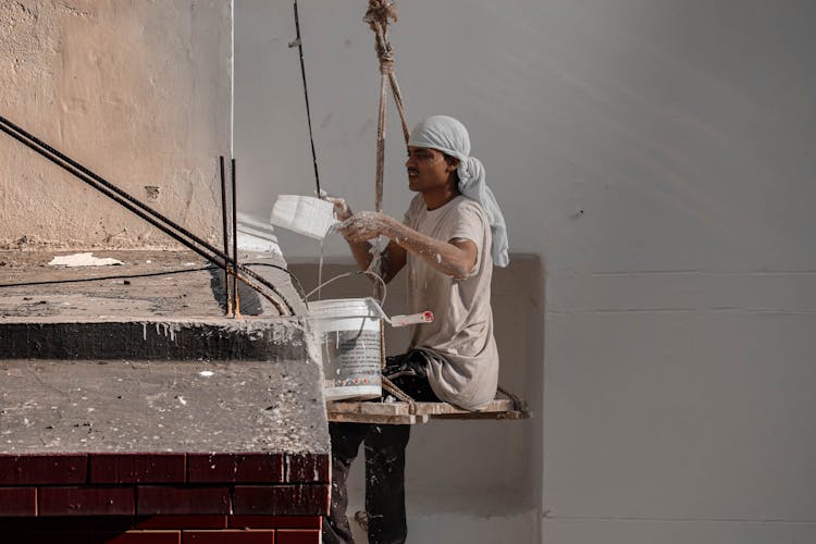 A Construction Worker Painting A Building