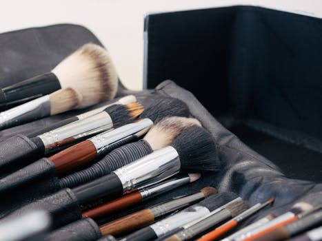 A collection of assorted makeup brushes neatly arranged in a leather case, ideal for beauty and fashion themes.