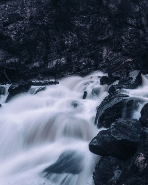 Free Captivating long exposure of a waterfall over dark rocks, showcasing natural beauty and tranquility. Stock Photo