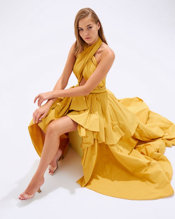 Woman in a butter yellow maxi dress in a meadow