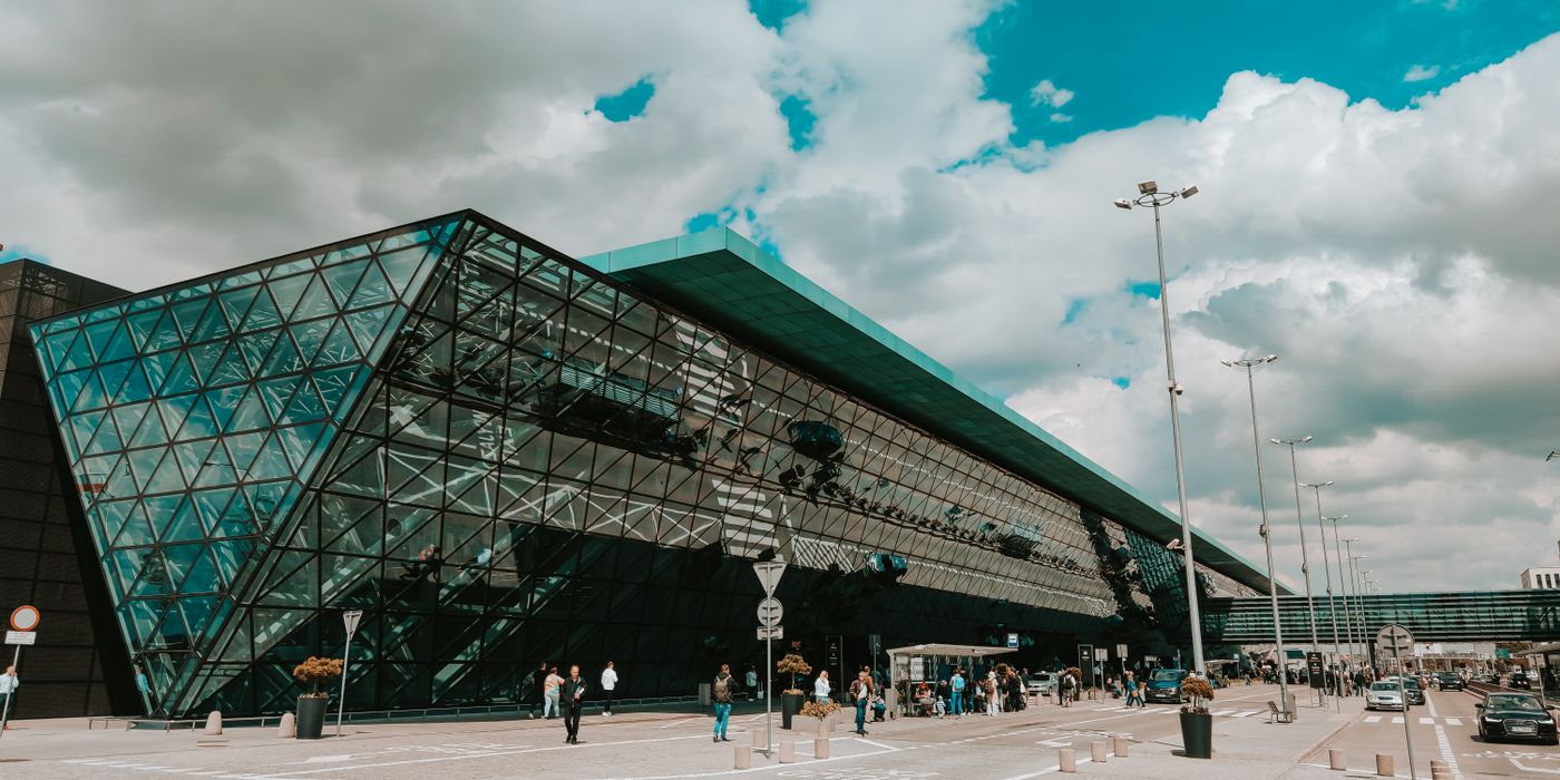 Modern airport terminal with a glass facade under a cloudy sky
