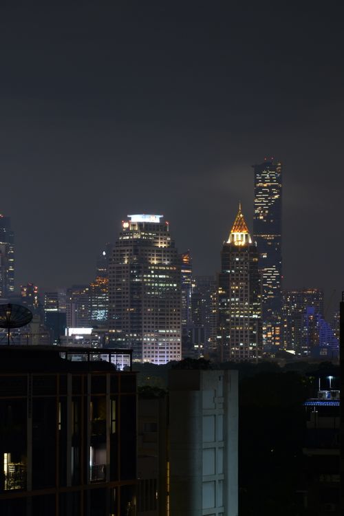 Free Stunning view of a city's skyline at night showcasing brightly lit skyscrapers under a clear sky. Stock Photo