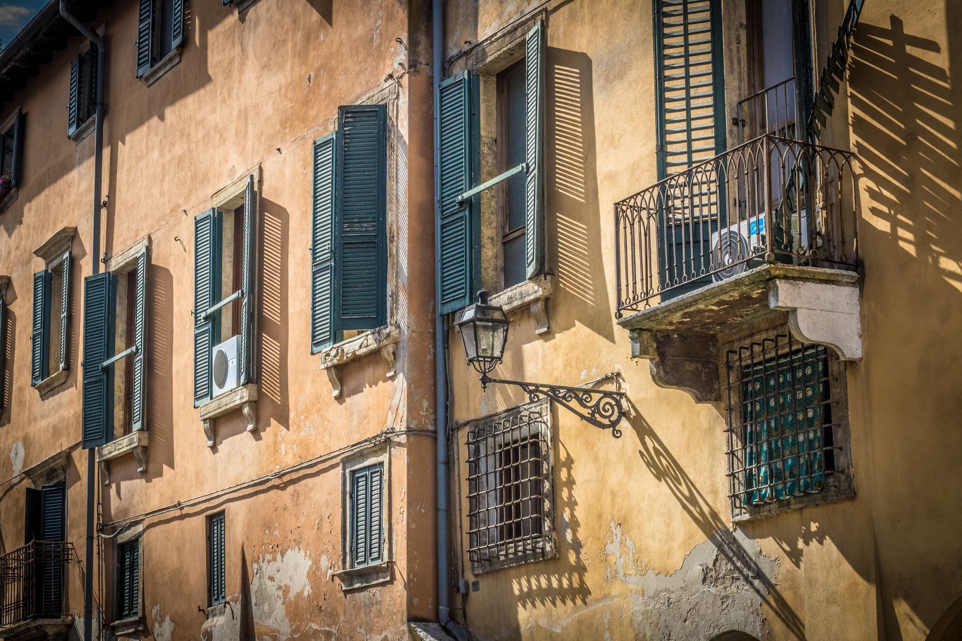 Charming old Verona building facade with shutters and balconies.