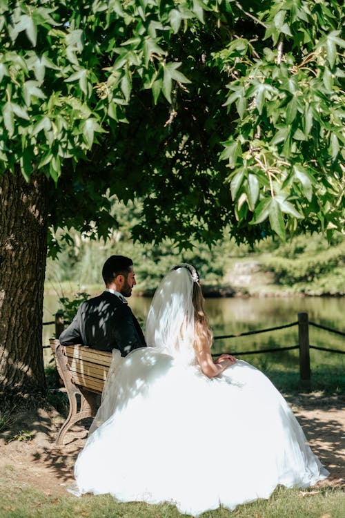 A Groom and a Bride Sitting on a Bench