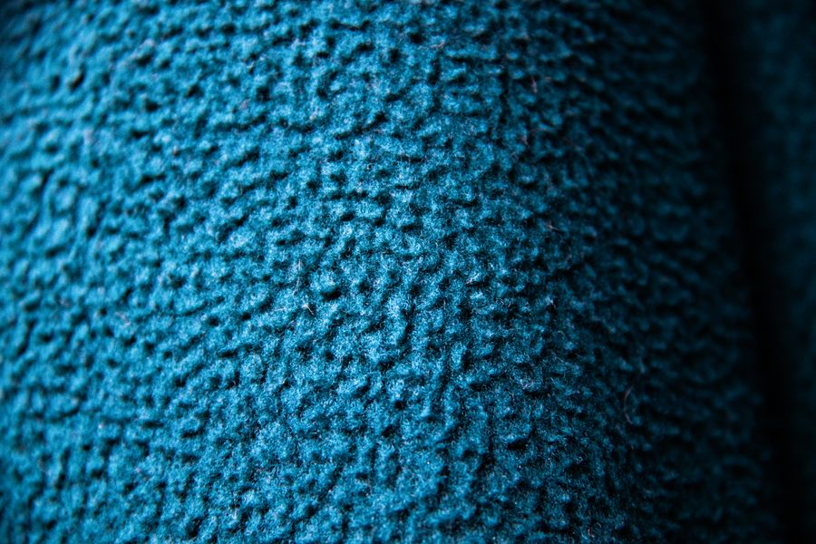 Detailed close-up showing the textured surface of blue wool fabric, ideal for textile and fashion themes.