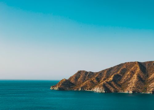 Free Stunning aerial view of Taganga's coastline in Colombia with clear blue skies and vibrant waters. Stock Photo