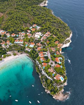 Explore the breathtaking aerial view of Cala Galdana, showcasing its turquoise waters and lush greenery.